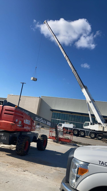 Boom lift and crane staged at commercial construction site